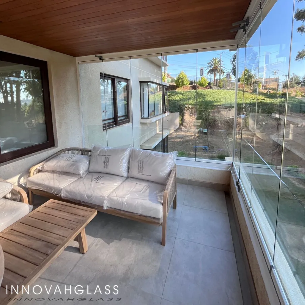 Terraza cerrada con cristal plegable y mobiliario